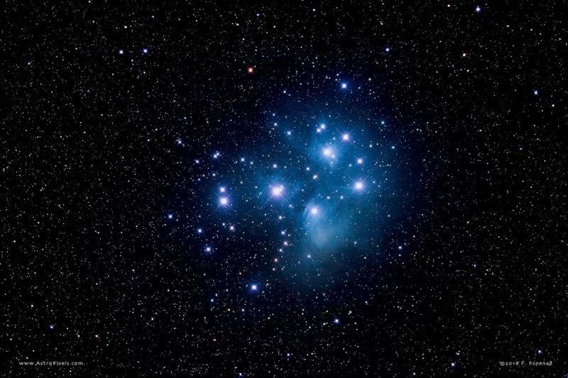 About a dozen brilliant blue-white stars in bluish mist against star field.