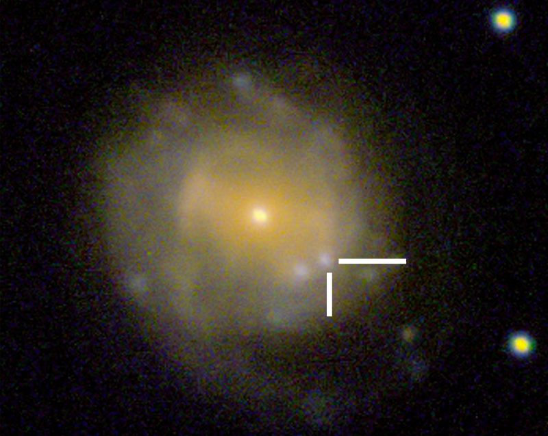 Blown-up image of a very distant galaxy, with the location of the flare-up indicated by tick marks.