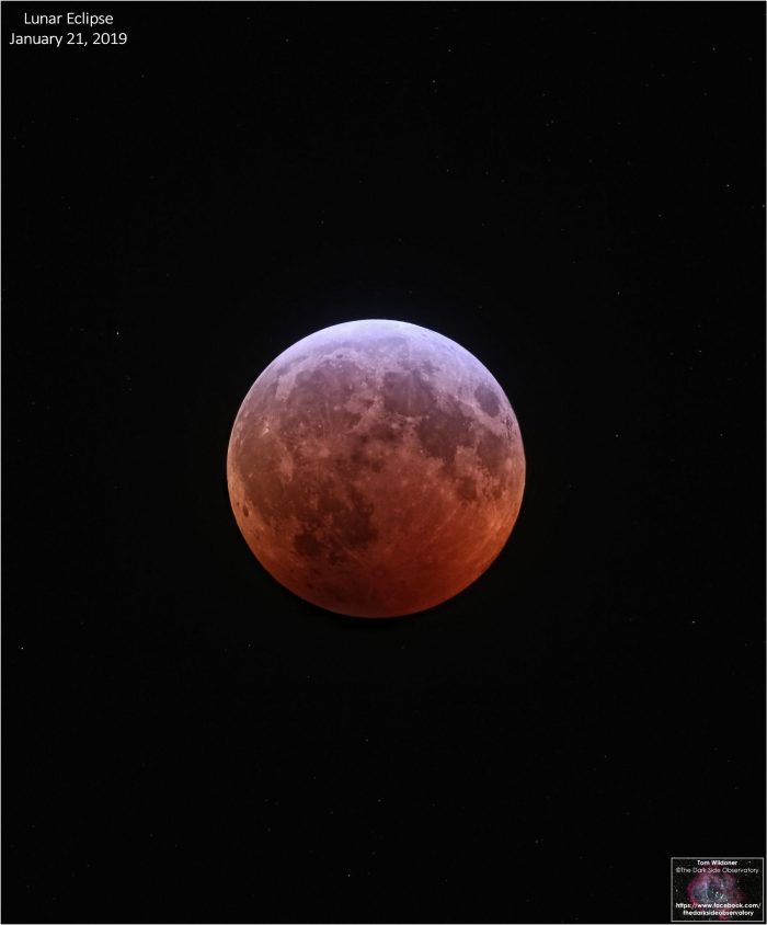 Full moon looking orange-red. Features visible on surface.