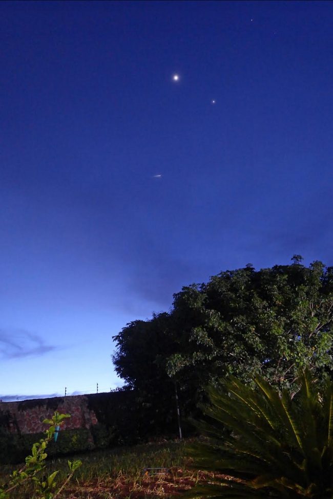 Bright dots of planets and stars, plus a short streak, the satellite.