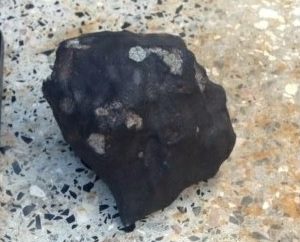 A black rock against a lighter background.
