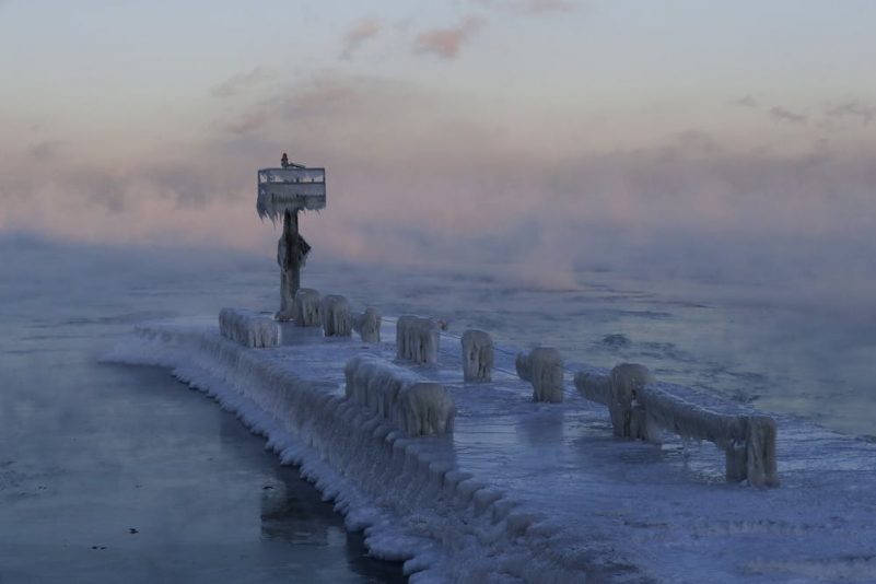 Pier and water covered in blue-white ice.