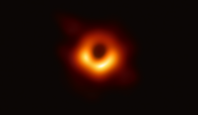 Black holes: An irregular circular shell of yellow-to-red light surrounding a black center.