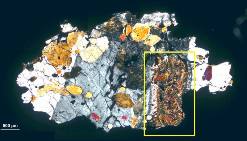 Irregular colored blotches like crystals in a cut section of a rock.