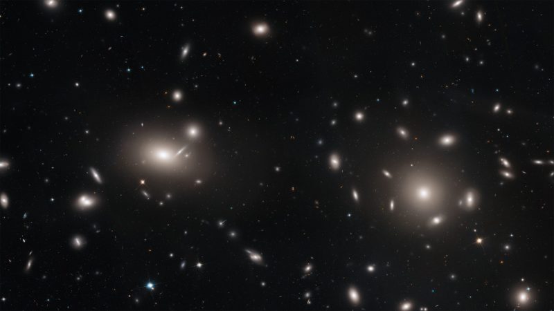 Coma Berenices Galaxy Cluster: Black background with large ovals of light and smaller points and smudges.