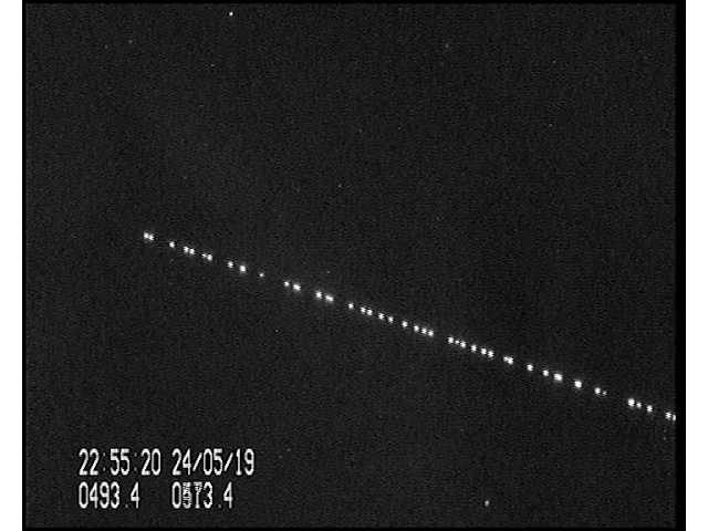 Starlink satellites - a line of bright dots against a black night sky - soaring overhead.