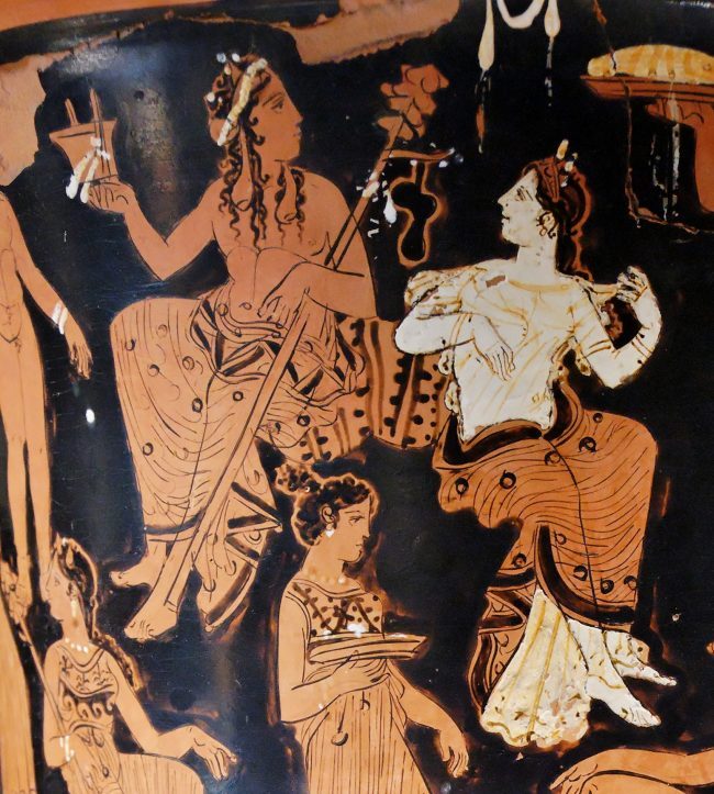 Seated man and woman in Grecian garb painted in red, white, and black on pottery.