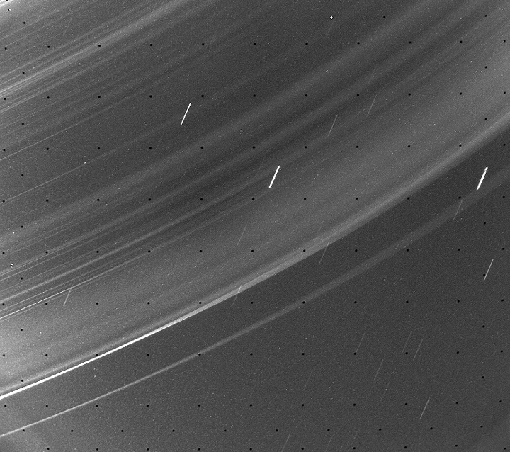 Partial view of wide, faint rings with short star trails seen through them.