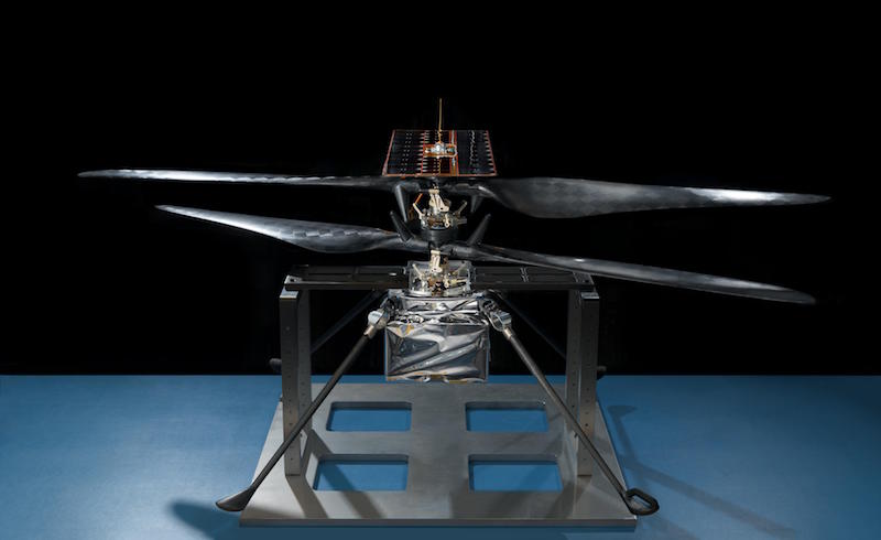 Two counter-rotating helicopter blades atop machine with large, flat square base.
