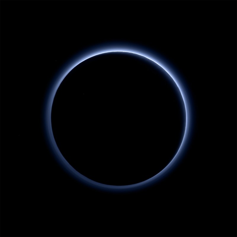 Dunkle Silhouette des von hinten beleuchteten Pluto, umgeben von blauem Dunst.