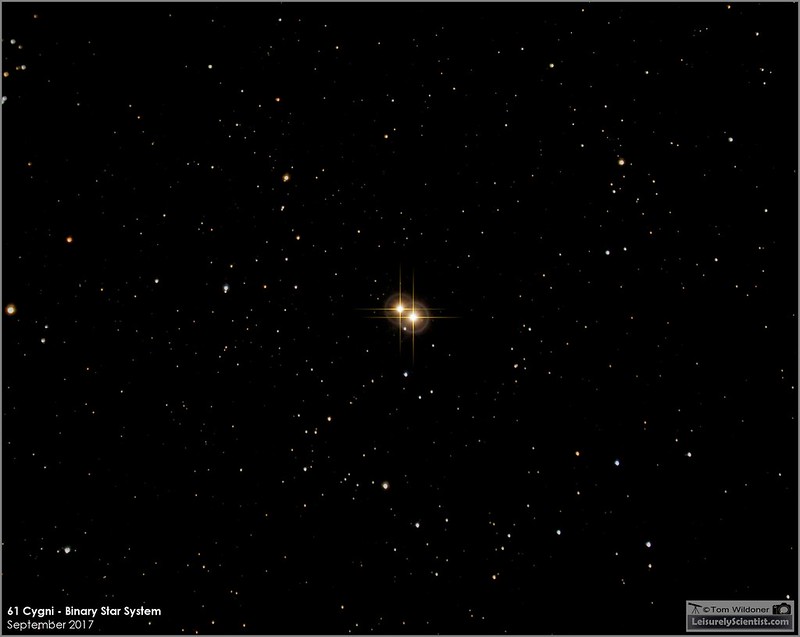 A sparse faint star field with two beautiful yellowish-orange stars, almost equally bright, in the center.