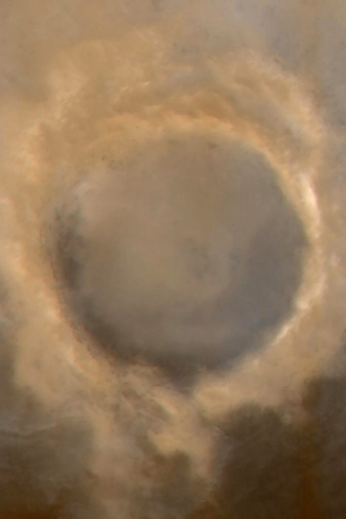 Fuzzy view of crater with dark brown, flat center and light tan rim.