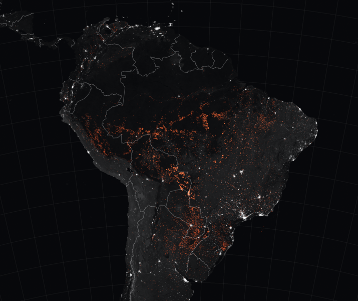 Nighttime orbital view of South America with light from cities and thousands of tiny dots.
