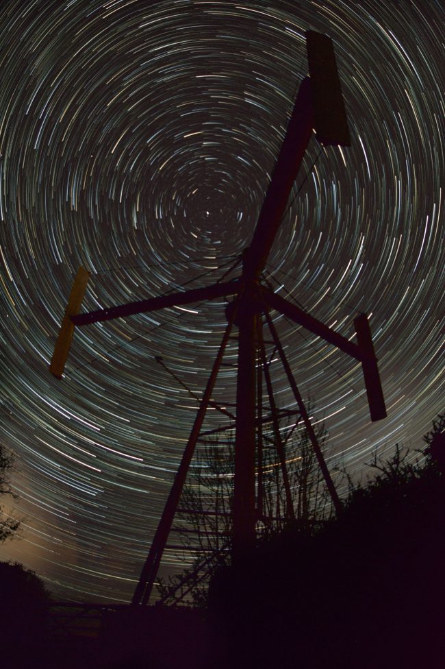 What are star trails? Dashes of light in a circle with black metal object in foreground.