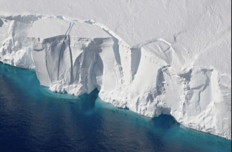 A tall ice cliff, with cracks indicating a calfing of the ice into the sea soon.