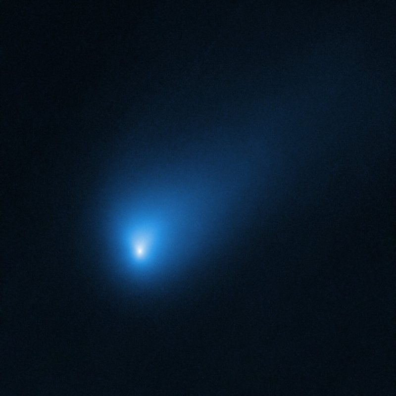 A fairly bright, bluish, fuzzy object with a visible comet tail.