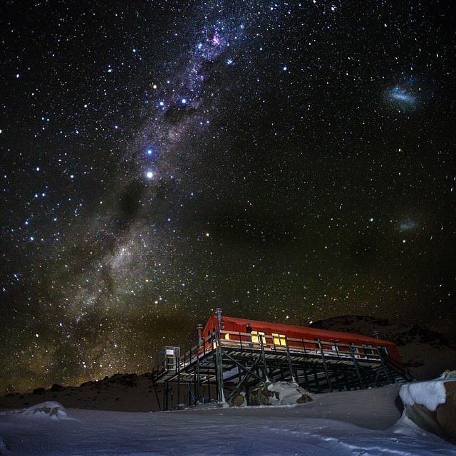 Field of brilliant stars over an ochre-colord building with a large deck around it.