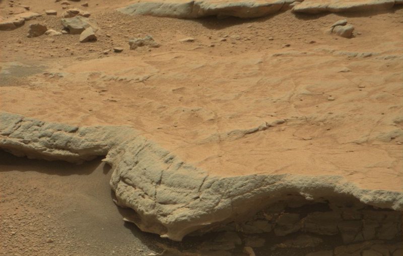 Textured rocks with red sand.