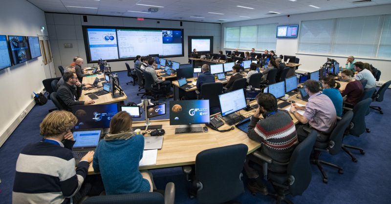 Scientists seated in front of computers, in a meeting room.