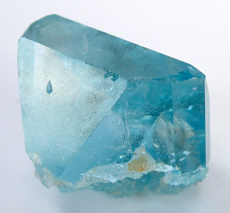 A chunk of clear light blue topaz, a natural crystal with flat sides.