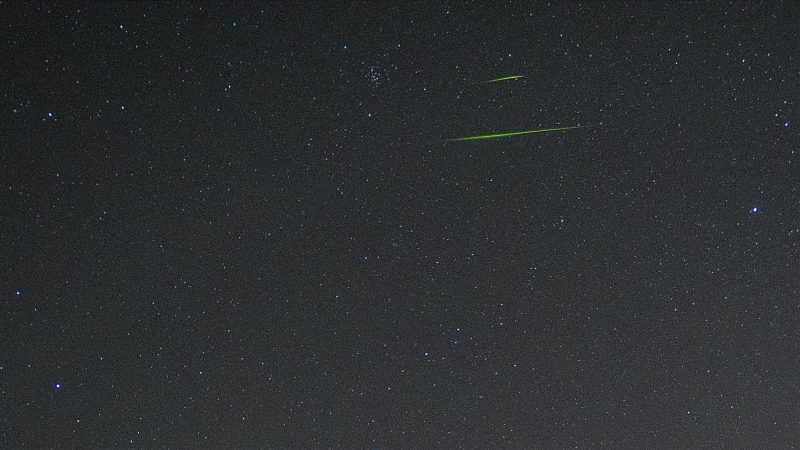 Two thin green horizontal streaks in dark starry sky.