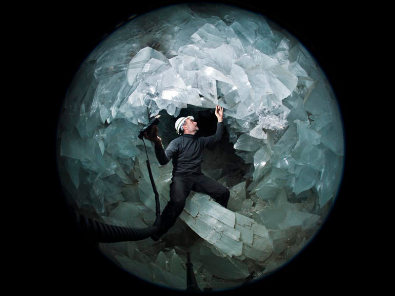 Man standing in the center of a giant crystal doughnut.