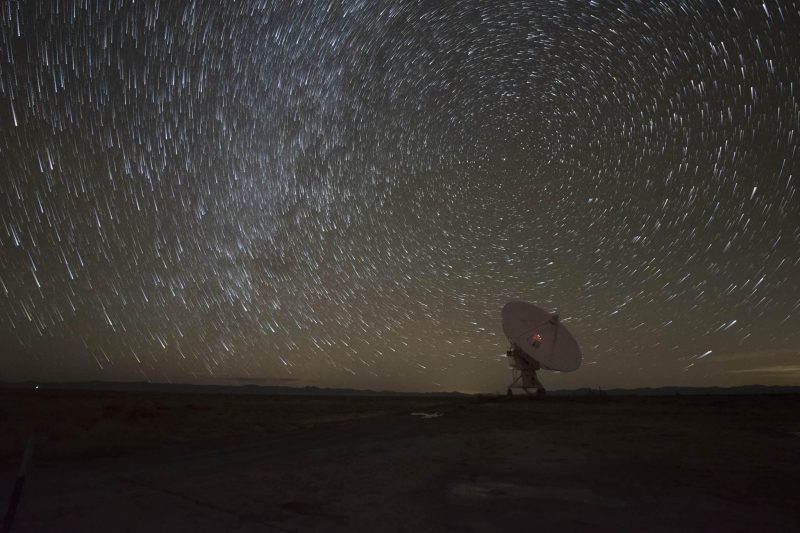 Distant, single dish-shaped antenna and circular star trails.