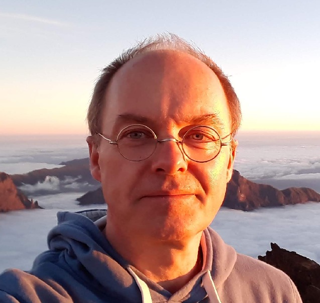 Man with glasses with islands in background.