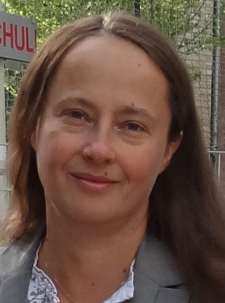 Woman with fence behind her.