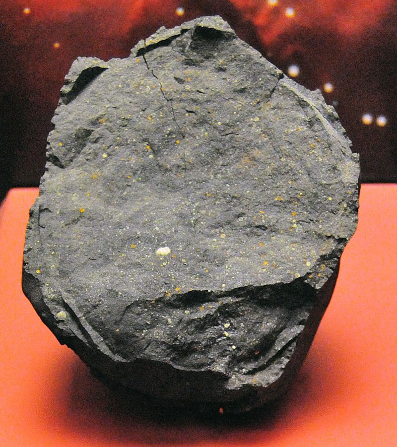 Gray rock with lighter speckles, sitting on a table.