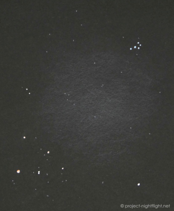 Stars as white dots and fuzzy whitish area between them on a black background.