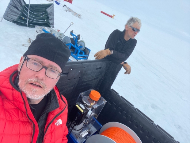 Two scientists in Antactica, with instruments scattered nearby.