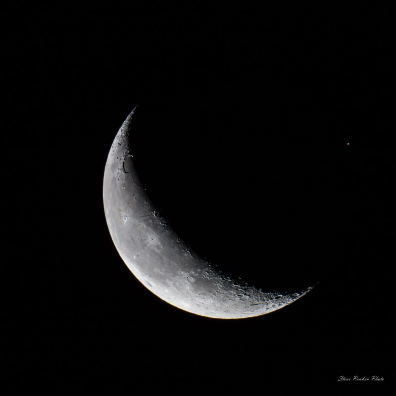 White crescent on a black background.