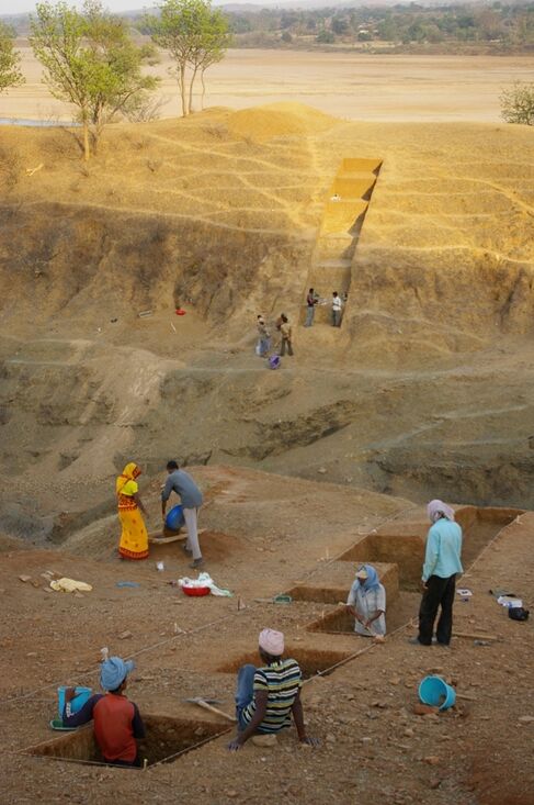 The excavation site, with trenches and people working on-site.