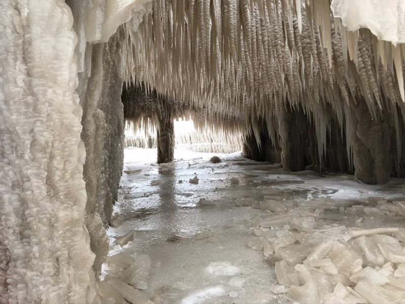 Thick ice in a covered driveway, with long icicles hanging from the patio's roof.