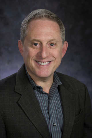 Smiling man in suit jacket.