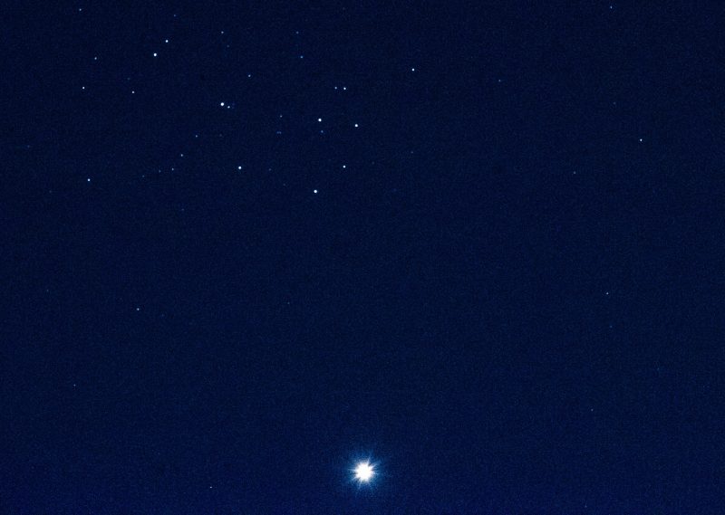 Rayed Venus at bottom with Pleiades at top.