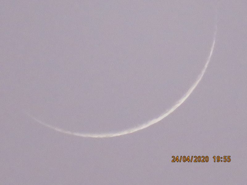 Very thin crescent young moon against lavender sky.