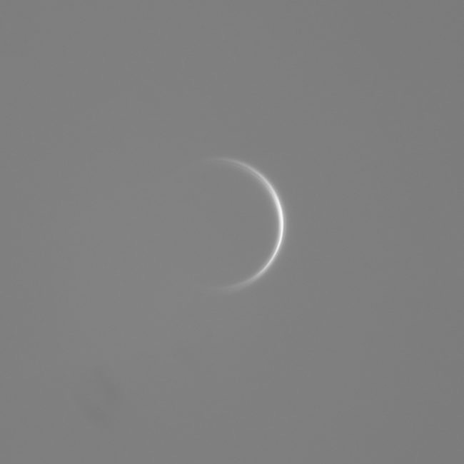 Very thin white crescent against gray background.