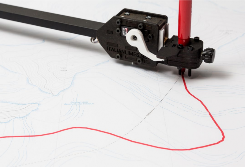 A topo map with a red line being drawn by an automatic pen on a mechanical arm.