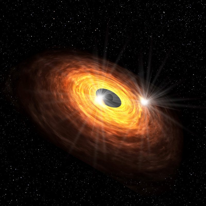 Glowing orange and yellow disk with a black center and a bright spot in the disk, against a starry background.