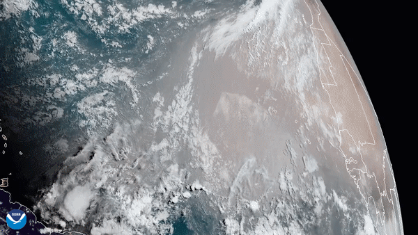Animated satellite view of large tan swaths being blown over the partly cloudy Atlantic Ocean.