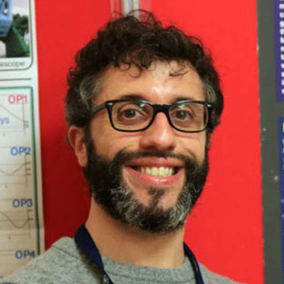 Smiling man with short hair, beard and eyeglasses.