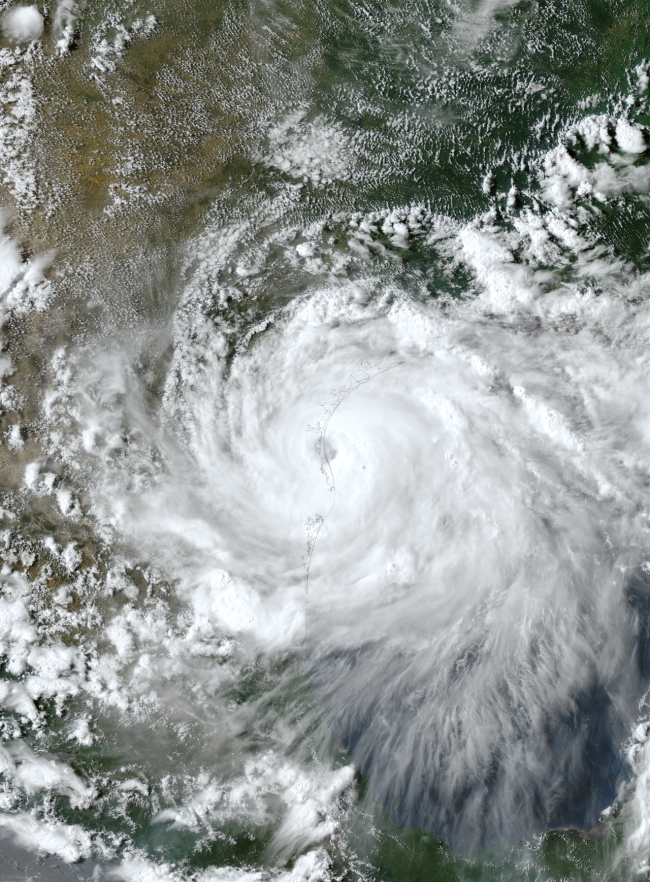 Orbital view of huge white spiral with dark dot in the middle next to Texas coastline.