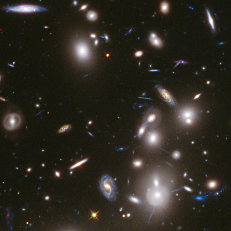 A cluster of galaxies - lots of bright oblongs and spirals, different sizes, all angles, on a black background.