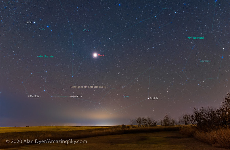 Annotated image showing the outlines of the constellations, labels for planets and satellite trails, against a starry night landscape. 