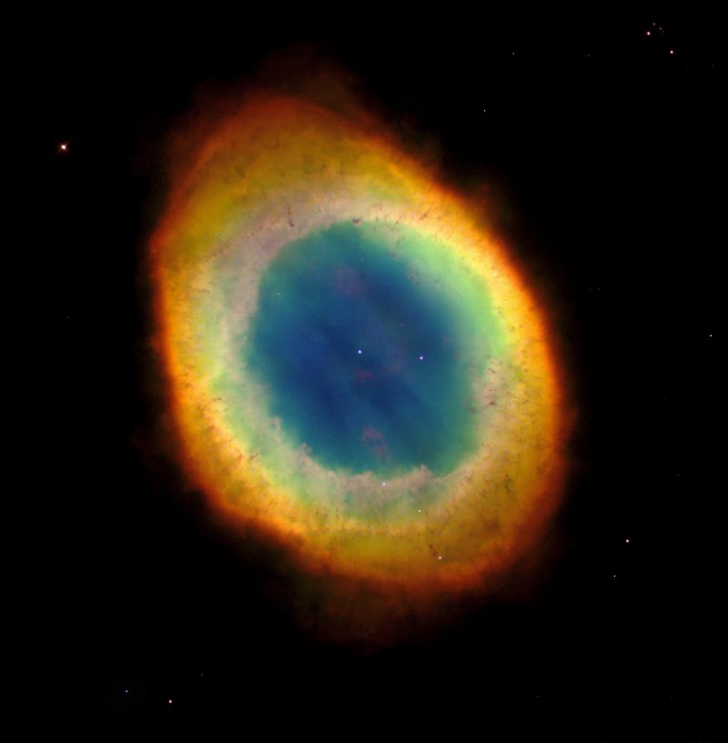 A colorful oval cloud in space, blue in the middle to orange and red on the outskirts.