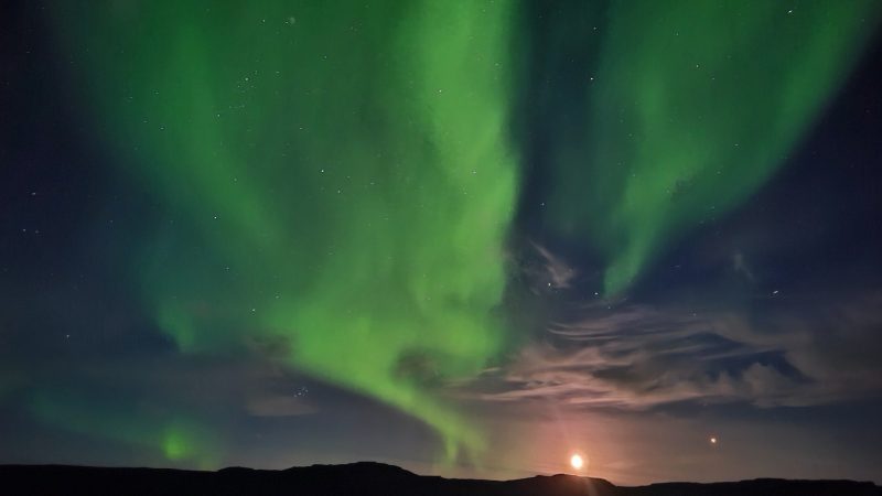 Moon and Mars rising above a ridgeline, with a glorious display of green northern lights filling most of the sky.