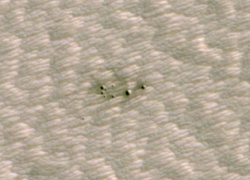 A cluster of small meteor craters on Mars.