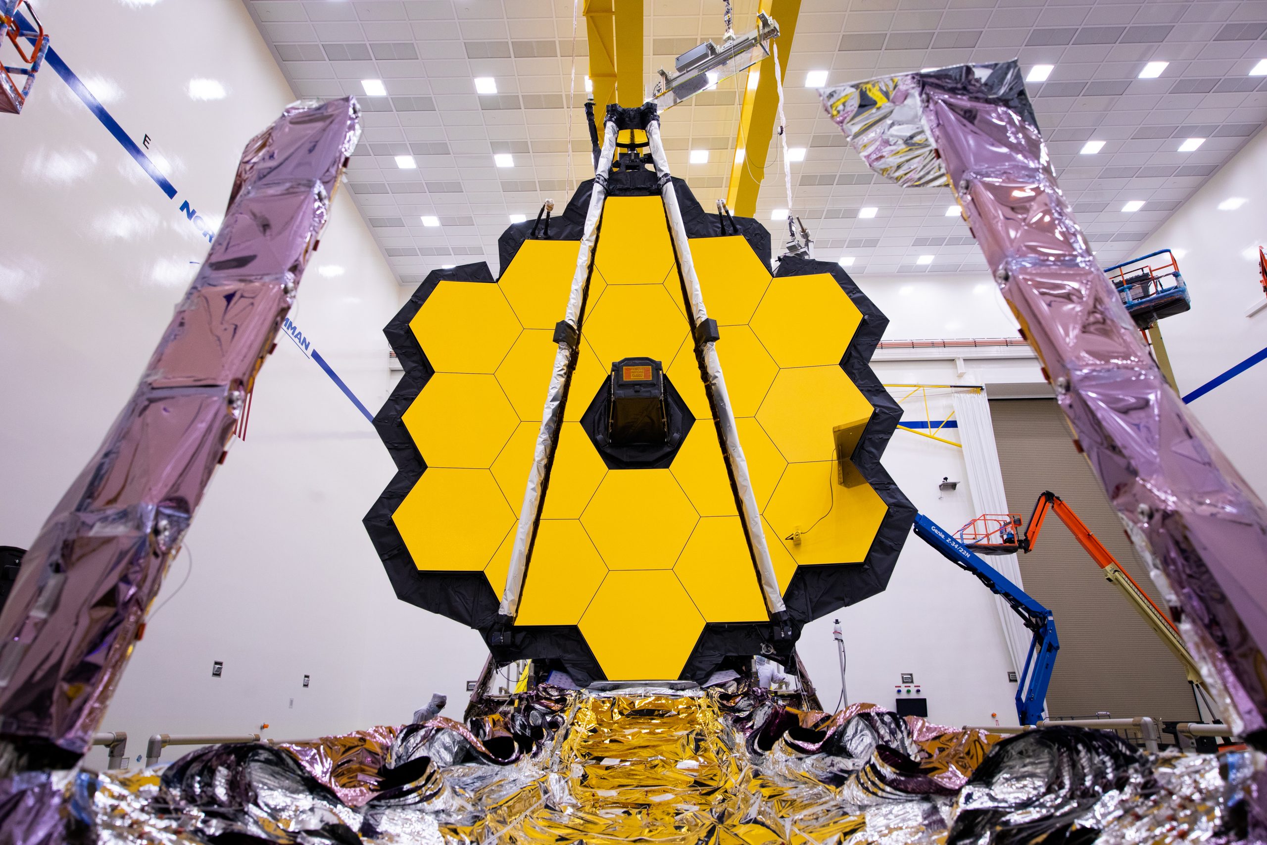 The James Webb Space Telescope displays its large and striking yellow sunshield with foldable structures surrounding it.